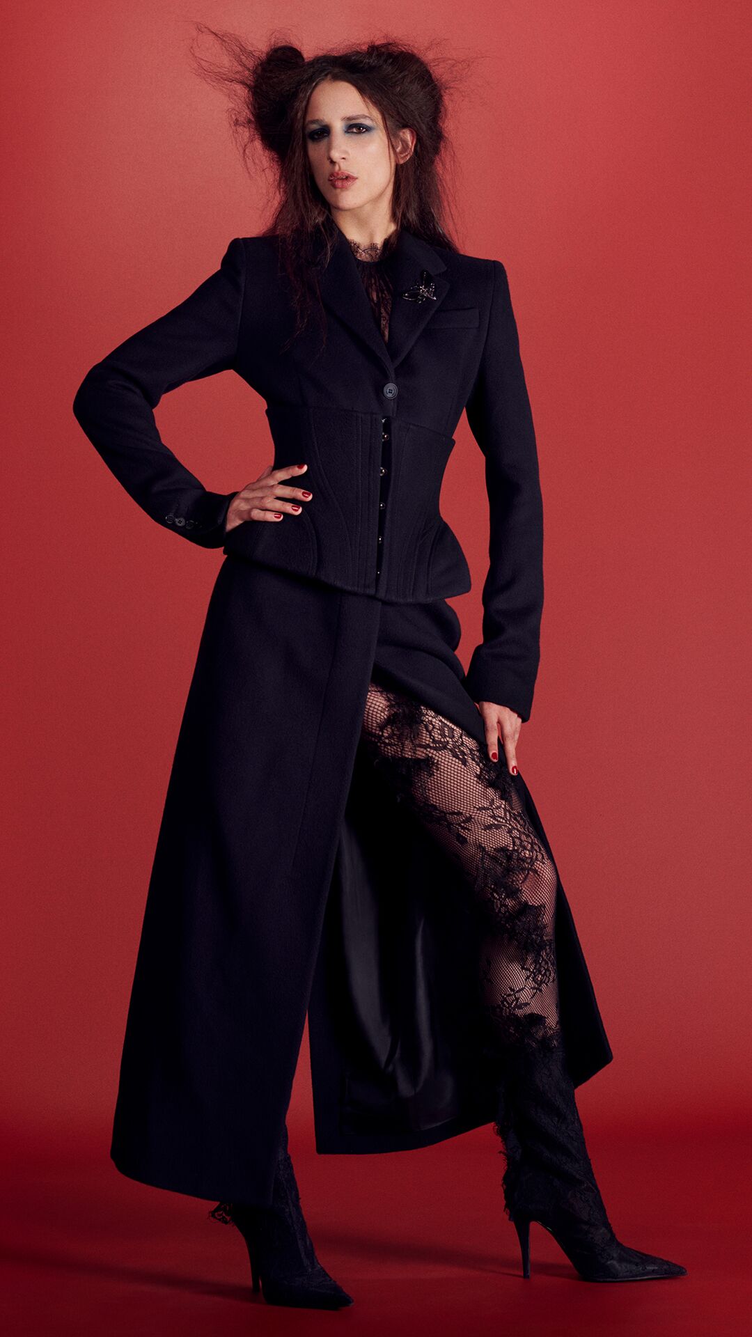 Women in McQueen coat and lace tights and boots