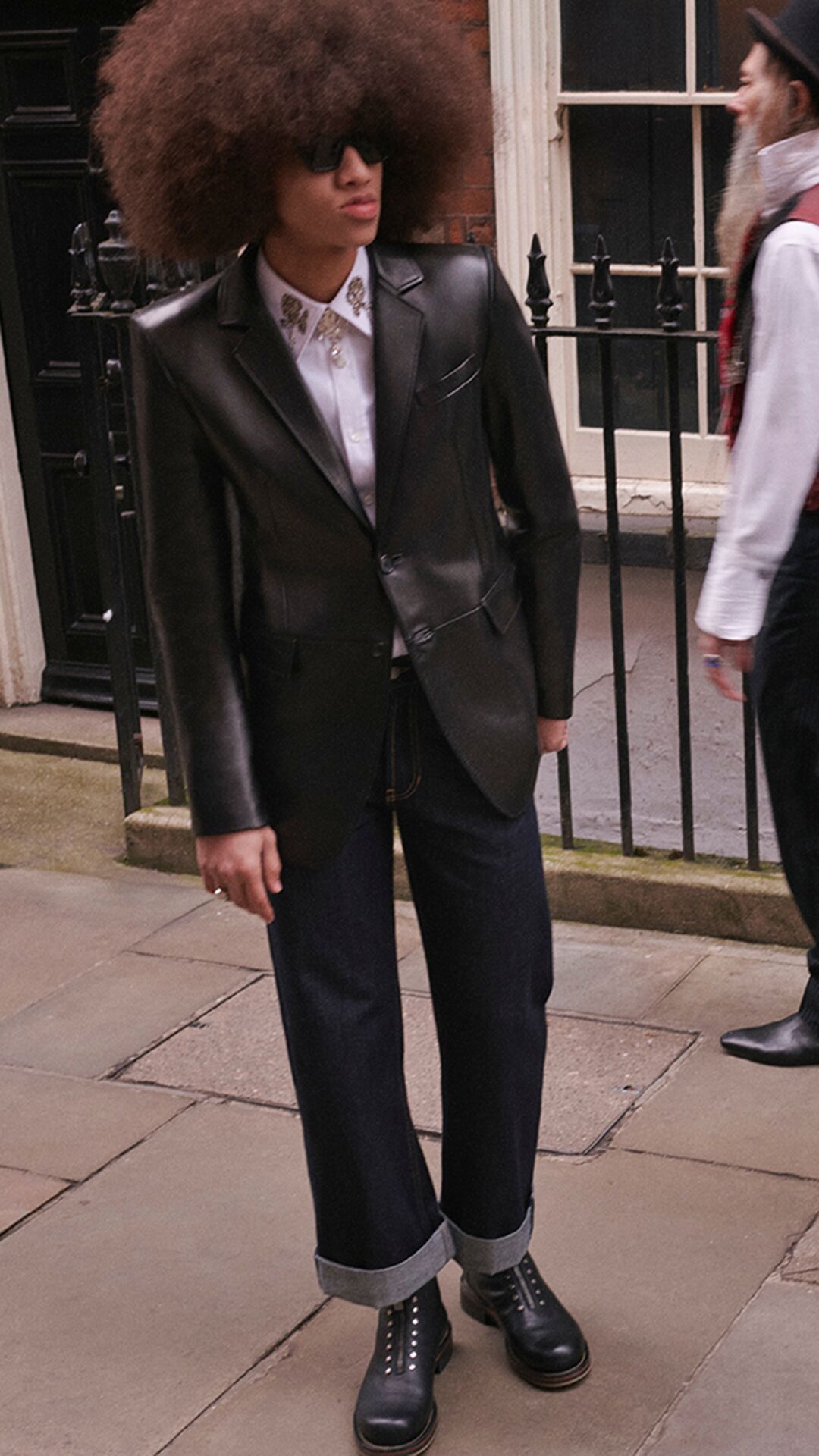 Man wearing McQueen black leather tailoring and blue indigo jeans