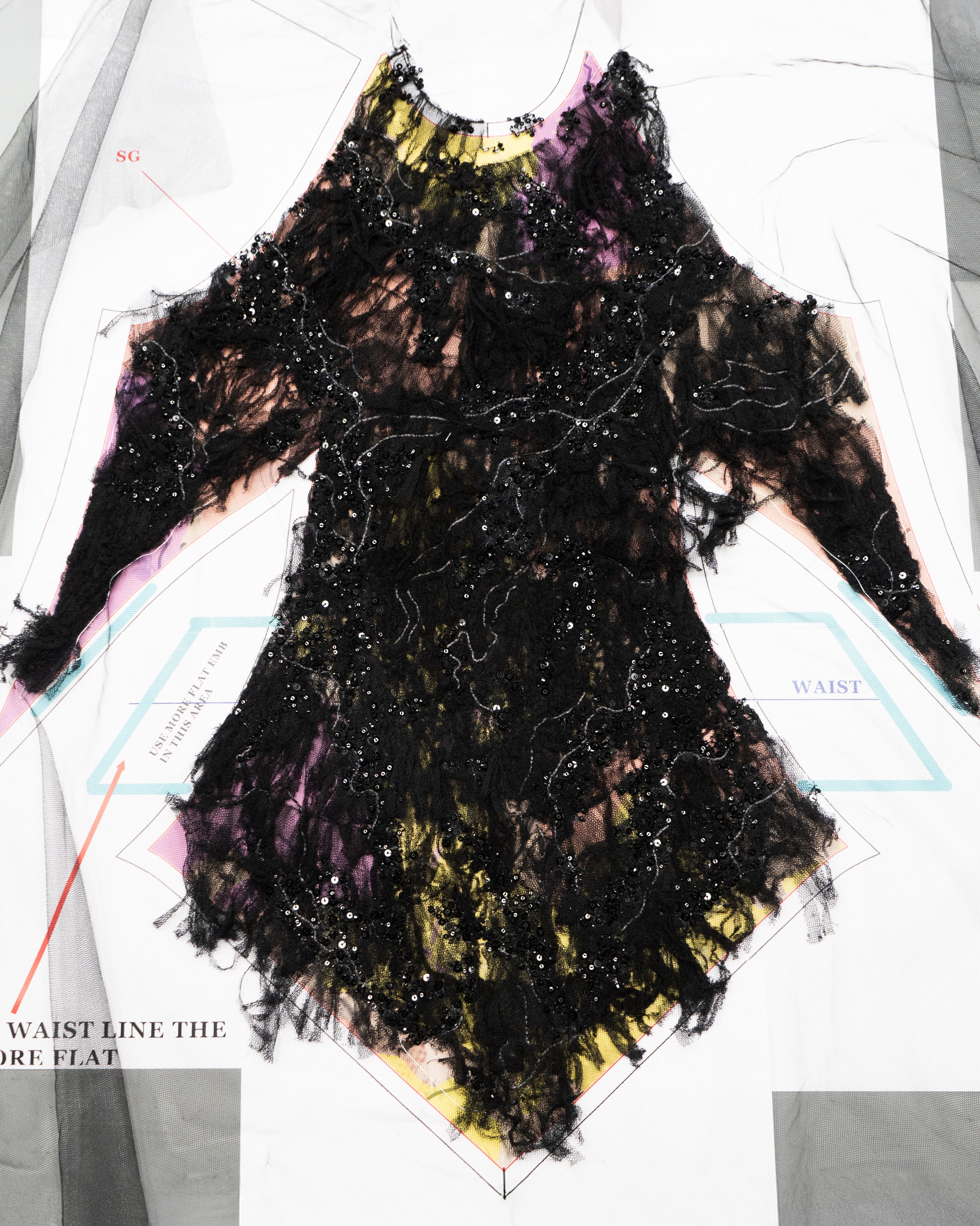 Black embroidered bodice laying on pattern table inside McQueen Atelier
