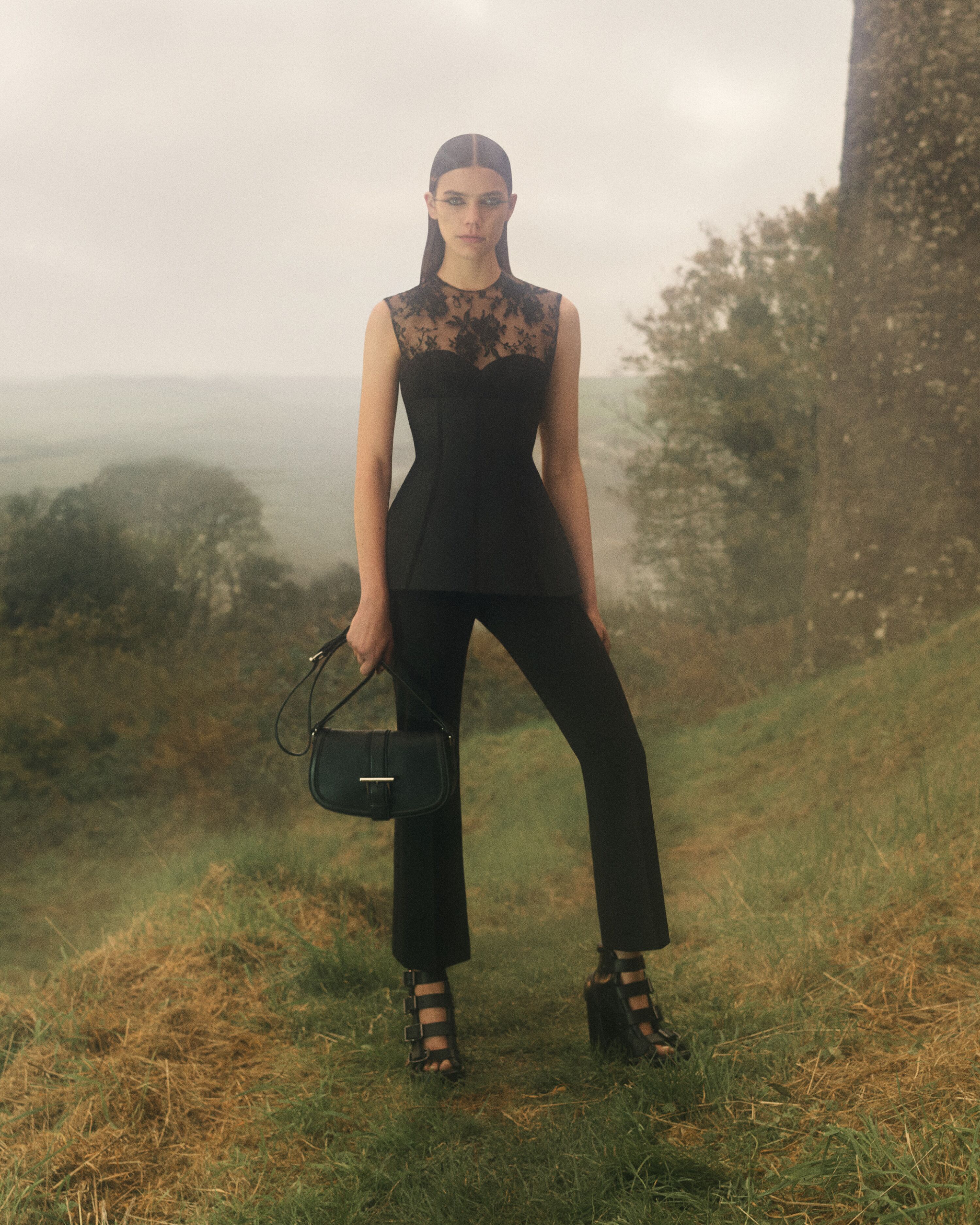 Model holding a McQueen T-Bar satchel in Black