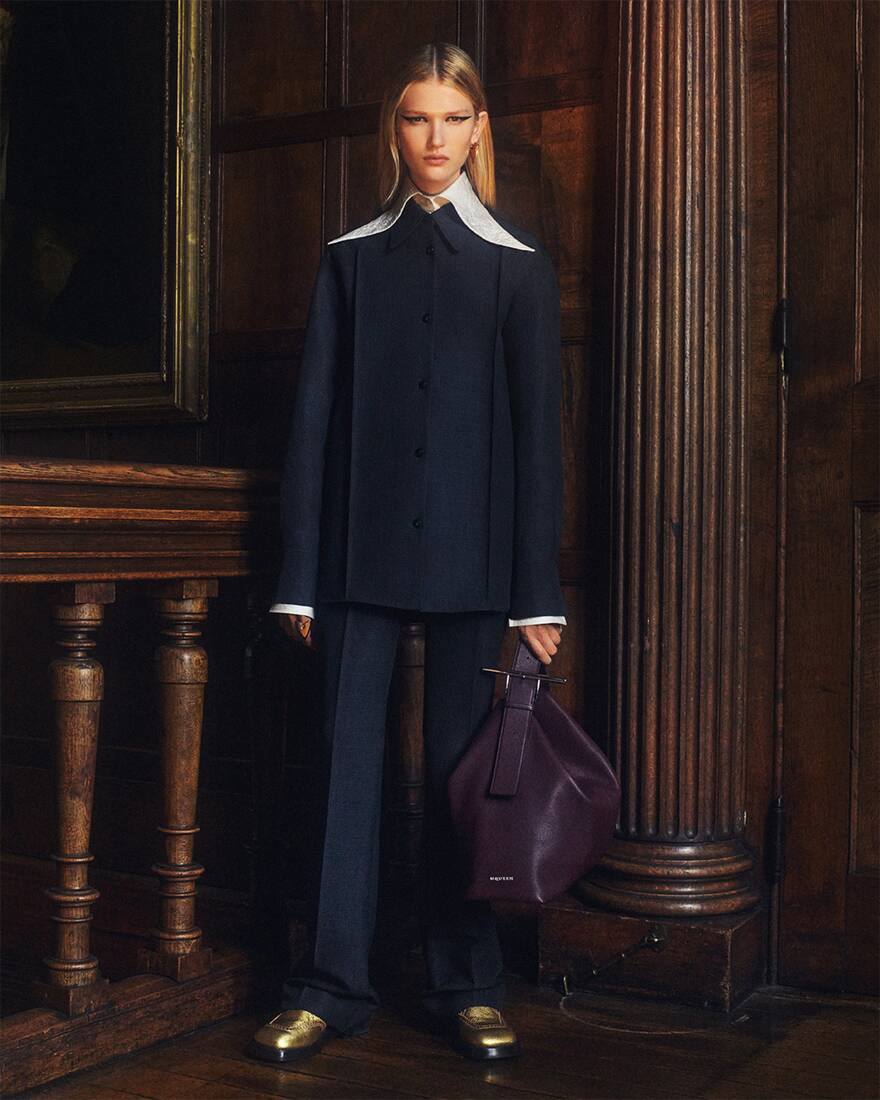 Women in McQueen tailoring with a burgundy slouchy t-bar bag