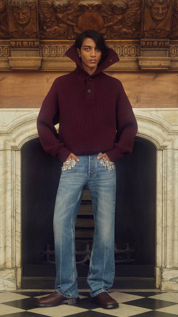 Man in a burgundy knitted sweatshirt with exaggerated collar