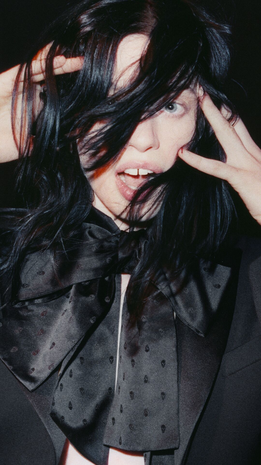 Women in McQueen coat and black bow hair tie