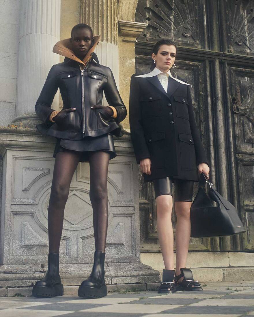 Rejoice Chuol and Shihana Shalaj wearing Alexander McQueen Spring Summer 2025 Pre-collection with T-Bar Sling Shoulder Bag in Black at Hatfield House