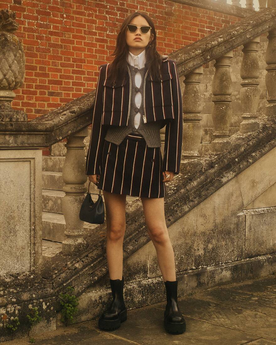 Women in matching pinstripe tailored jacket and skirt 