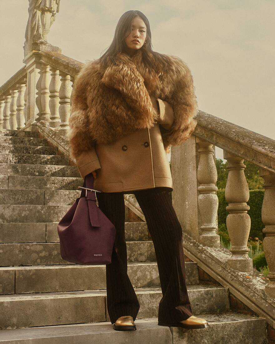 Women in a shearling coat and black tailored trousers