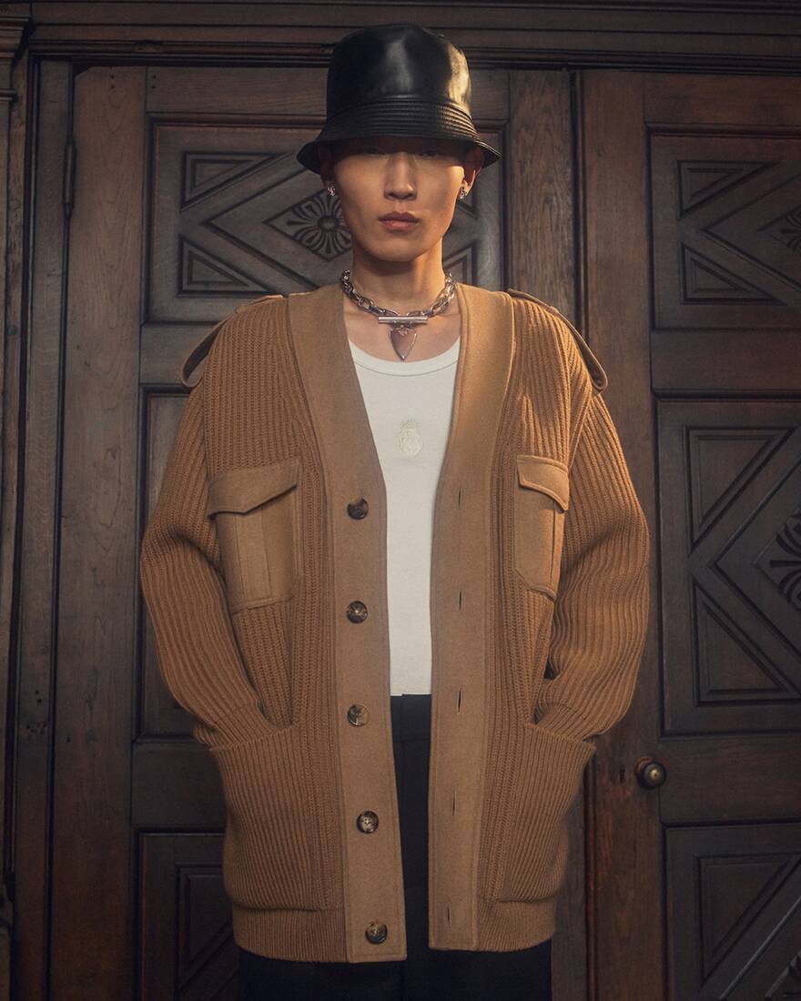 Man in brown cardigan and leather bucket hat