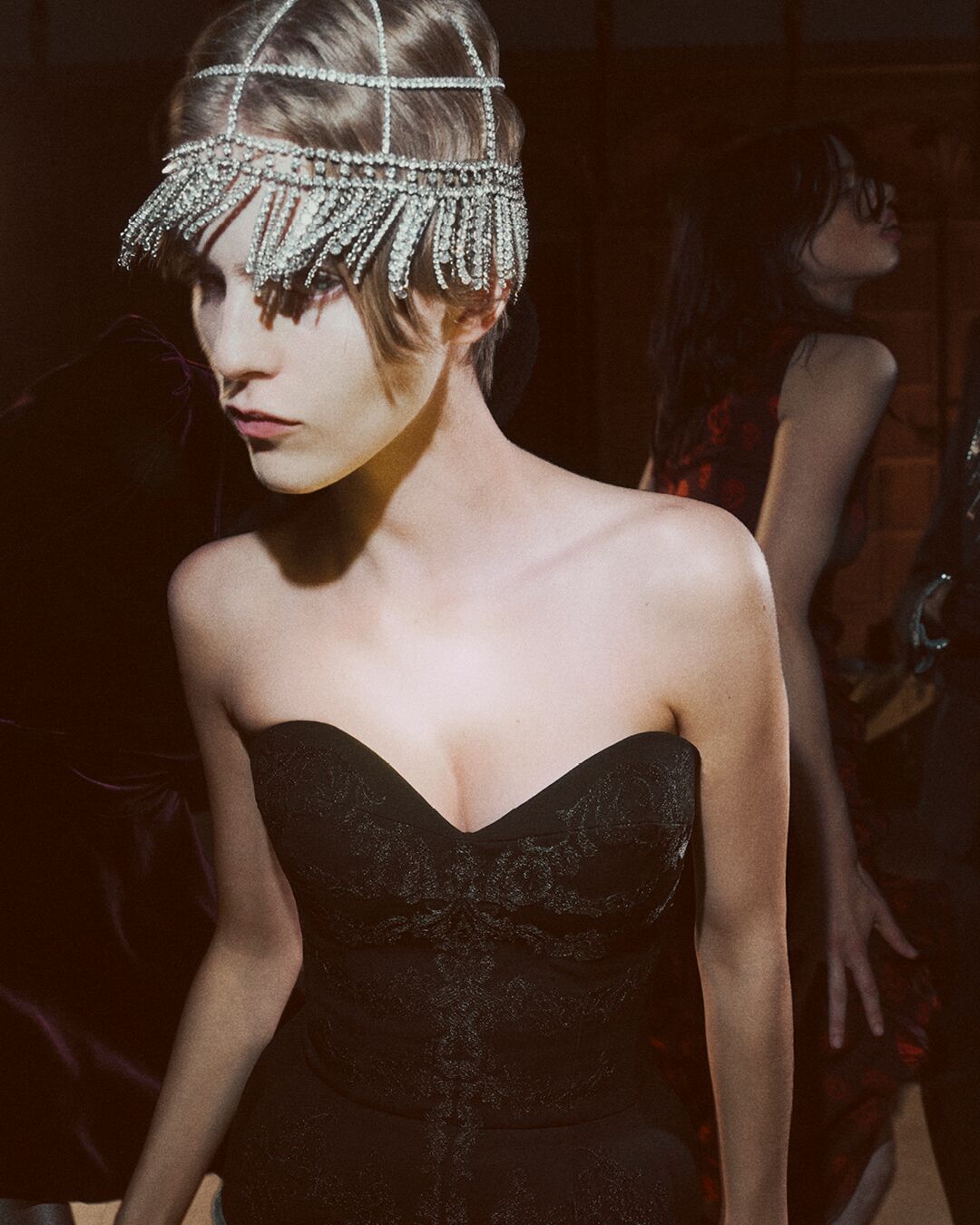 A person wearing a black dress and headpiece 