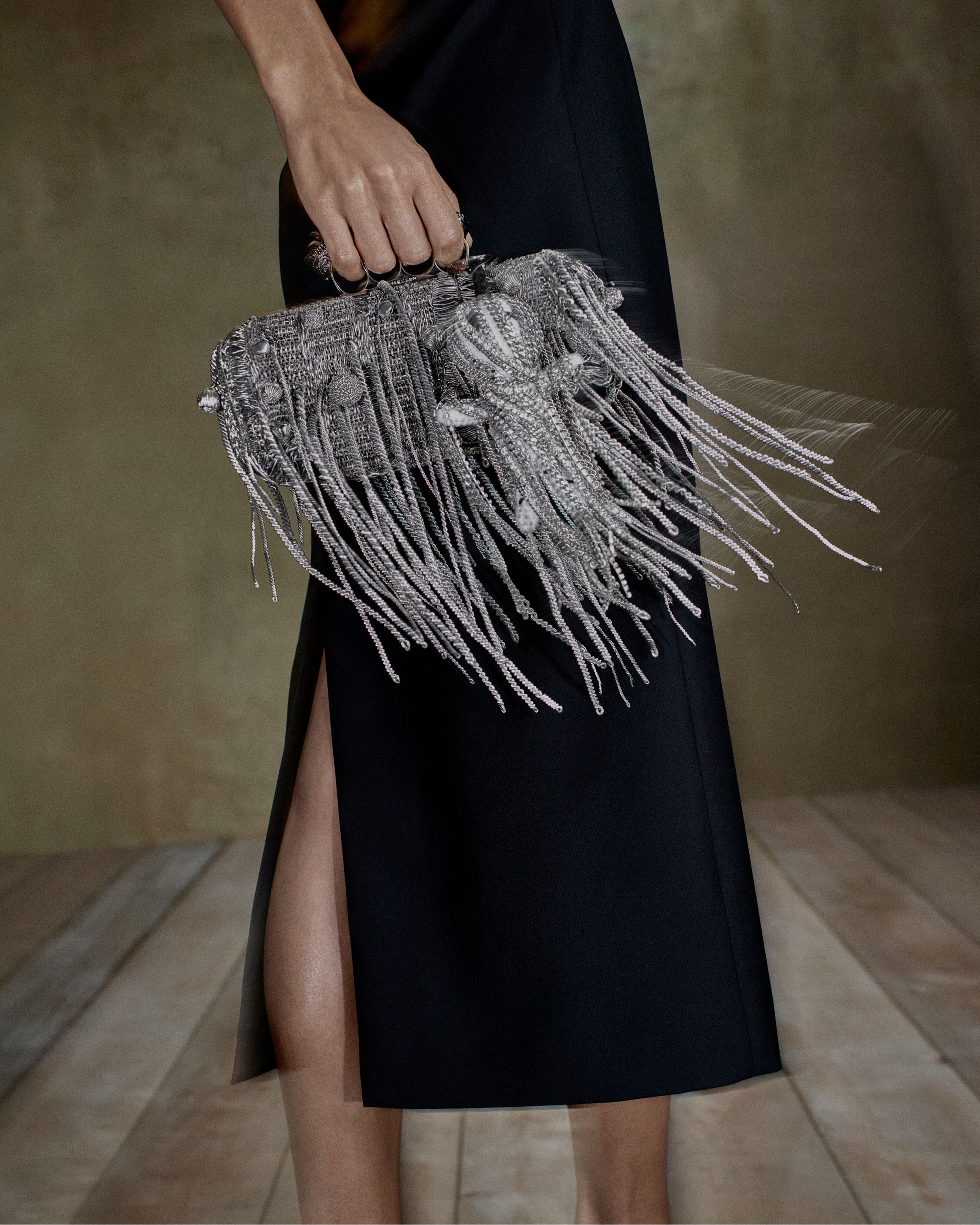 Women holding a McQueen embellished clutch