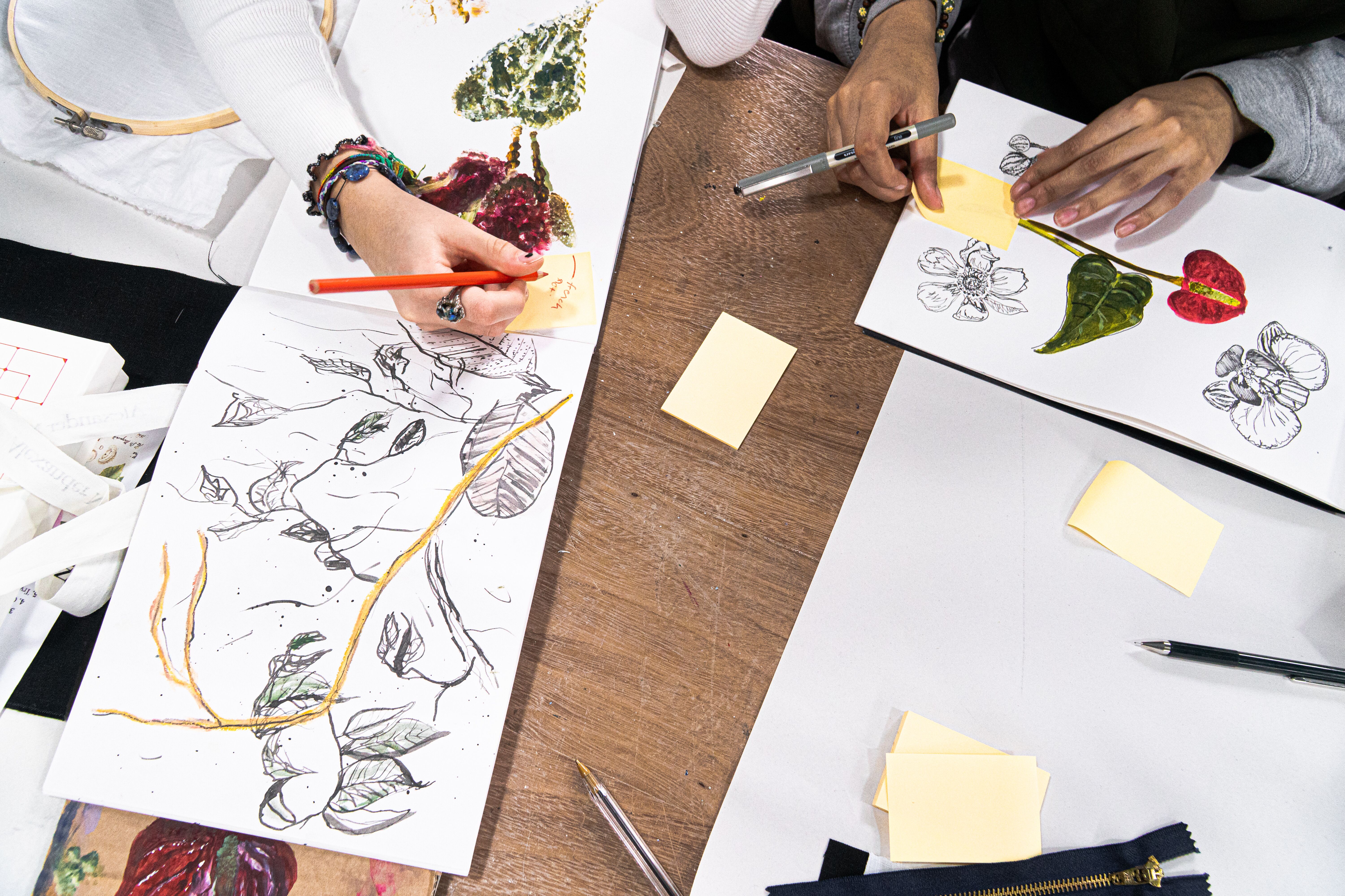 Students drawing floral designs for embroidery