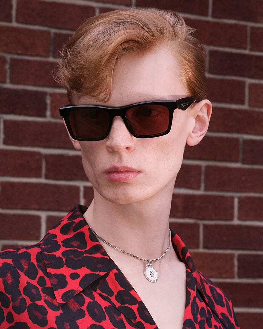 model wearing black sunglasses and silver necklace