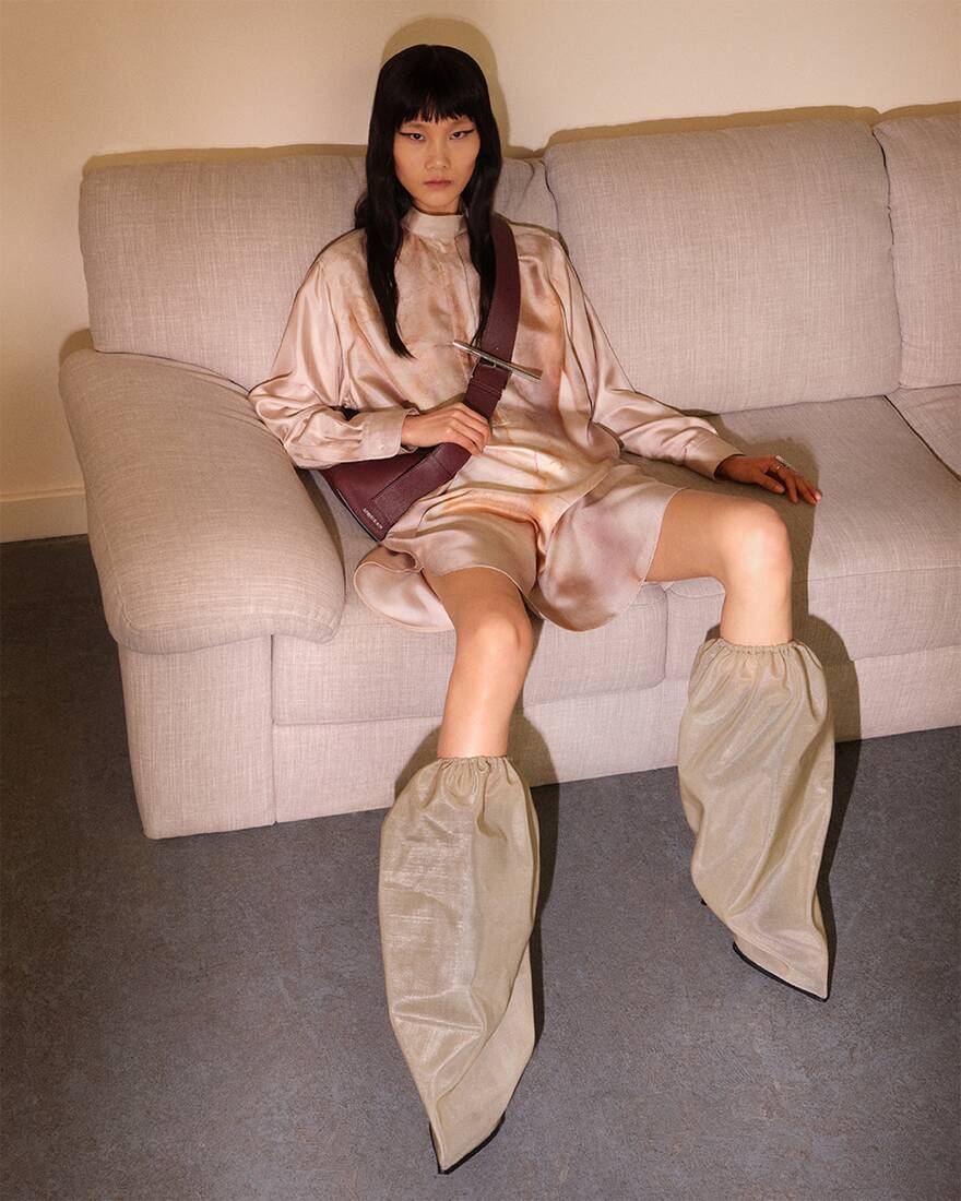 model with knee high boots sitting on couch