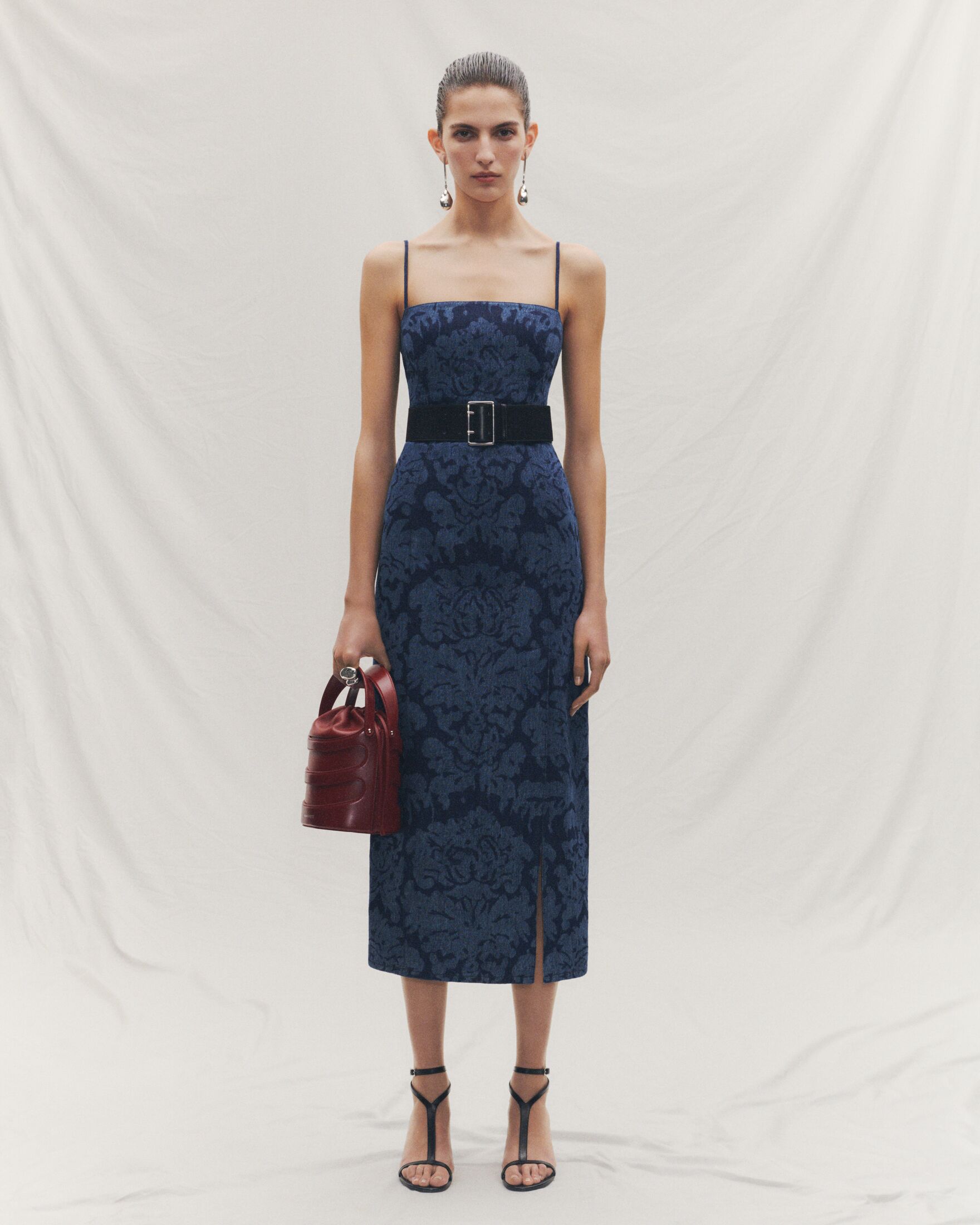 Denim midi dress with damask motif, red bucket bag and sandals