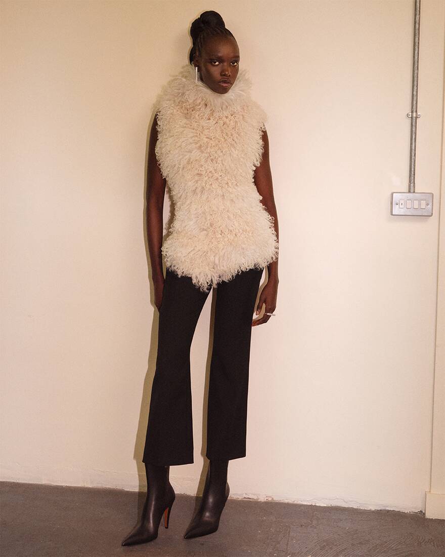 model in black trousers and shearling short sleeve top