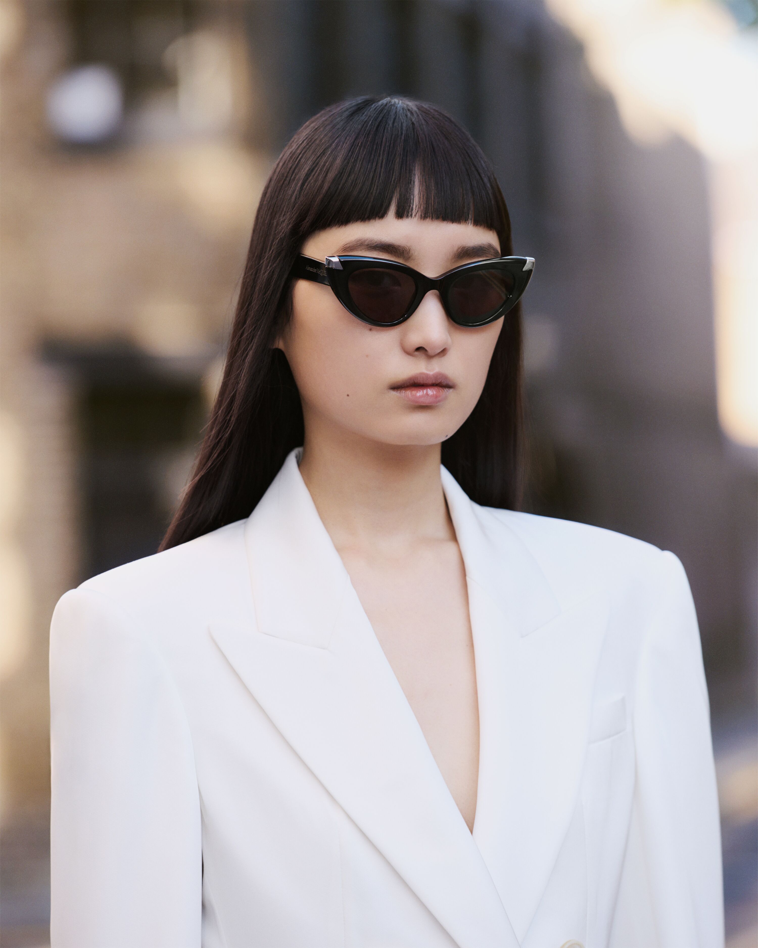 Wang with white tailored jacket and oval sunglasses