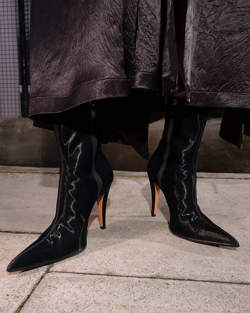 crop of model wearing pointed black heeled boots