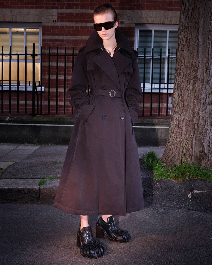 model wearing long black trench coat