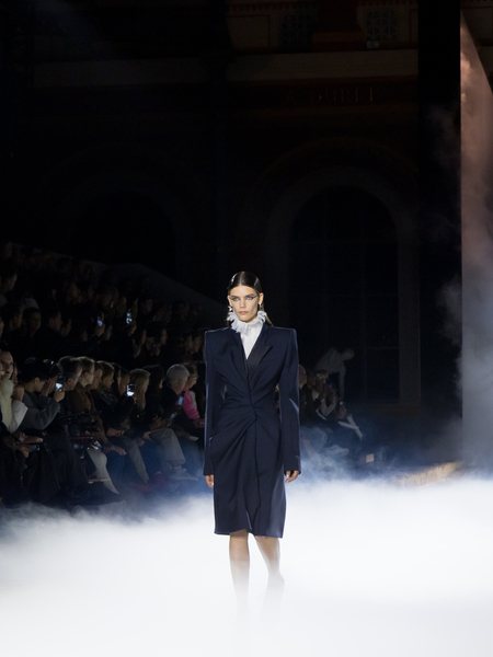 Model walking down wearing a black tailored dress