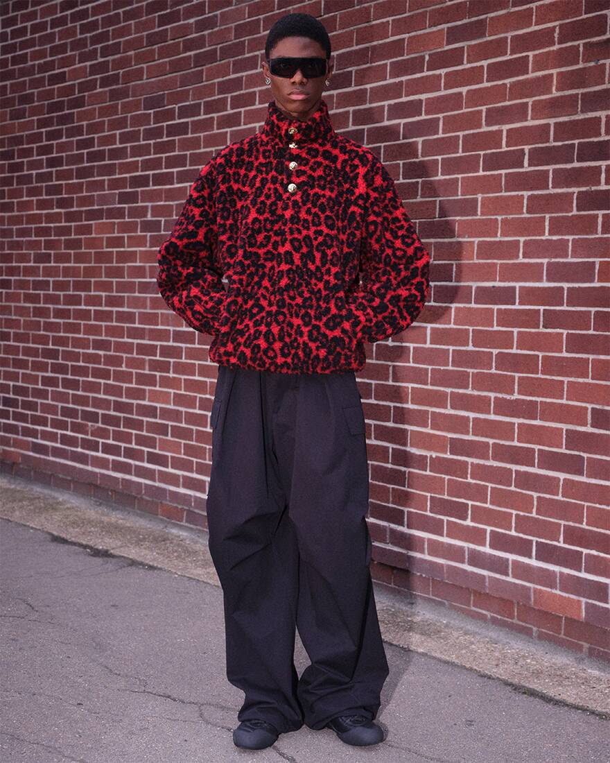 model wearing red leopard jumper, and trousers